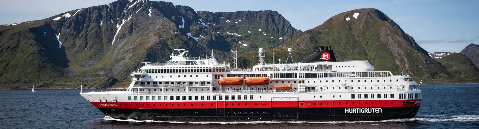 Hurtigruten schip tijdens een Hurtigruten kustreis langs de ruige Noorse kust bij Bergen, onderdeel van een Hurtigruten cruise in Noorwegen.