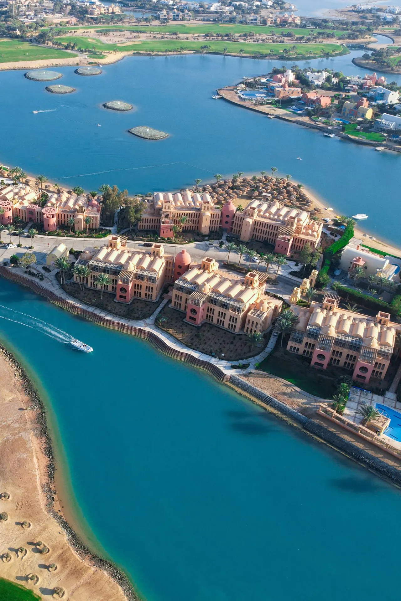 Luchtfoto van El Gouna aan de Rode Zee in Egypte, met luxe resorts, helderblauwe lagunes en stranden die als eilanden met elkaar verbonden zijn. De architectuur langs het water, jachthavens en kustlijnen tonen het exclusieve karakter van deze populaire zonbestemming.
