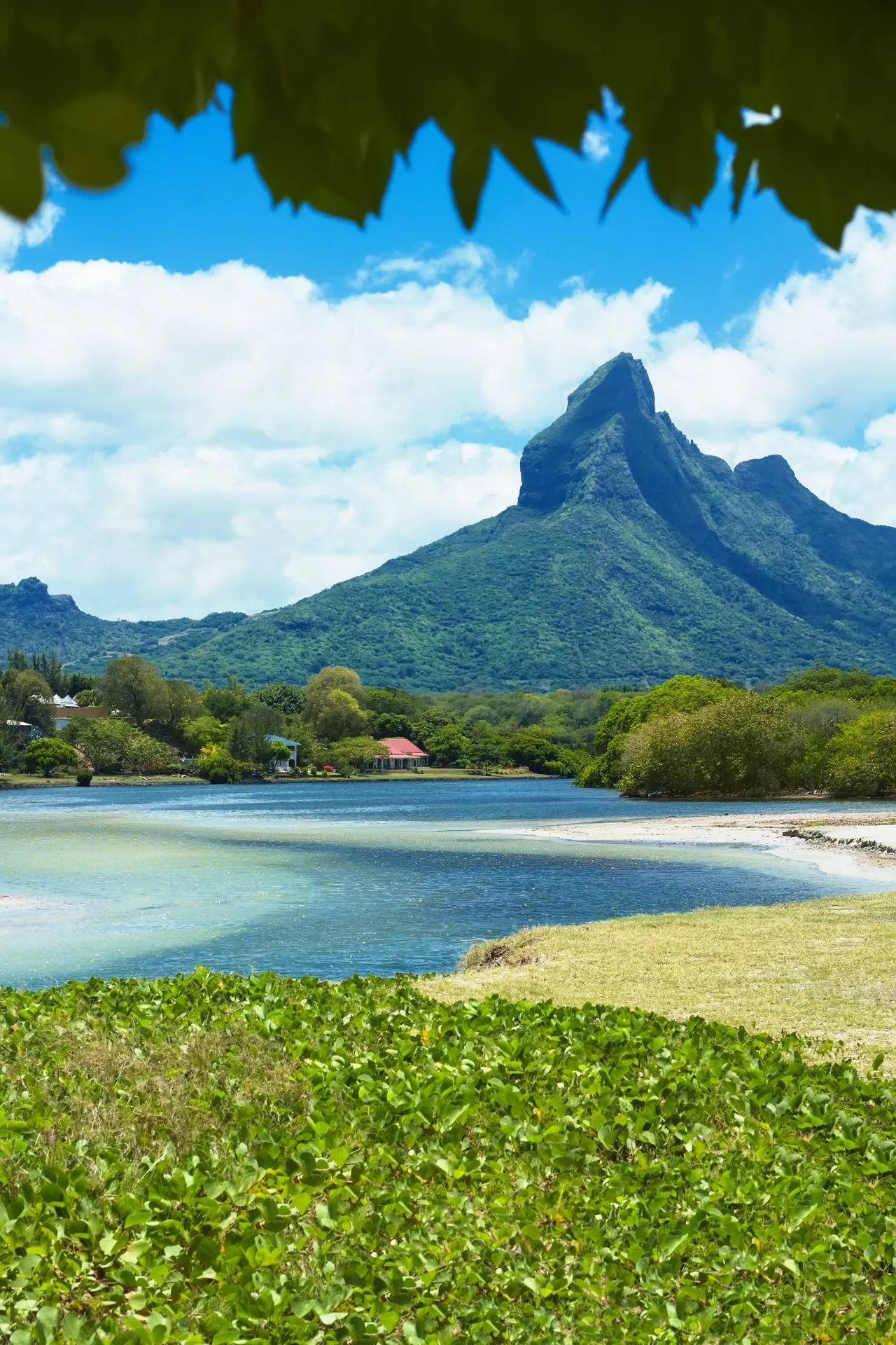 Een prachtig uitzicht op een bergachtig landschap en een rustige lagune in Mauritius. Ideaal voor reizigers die een goedkope vakantie naar Mauritius willen combineren met natuur en ontspanning.