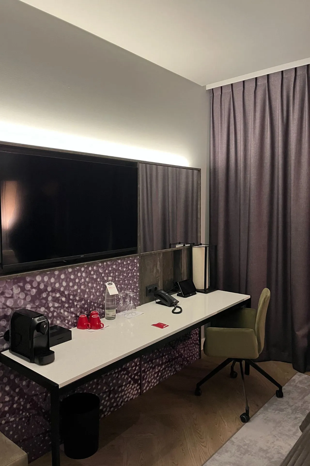 Een modern hotelbureau met een flatscreen-tv, een koffiezetapparaat en luxe details, perfect om te ontspannen of werken tijdens het verblijf in Leonardo Royal Munich Hotel. 

