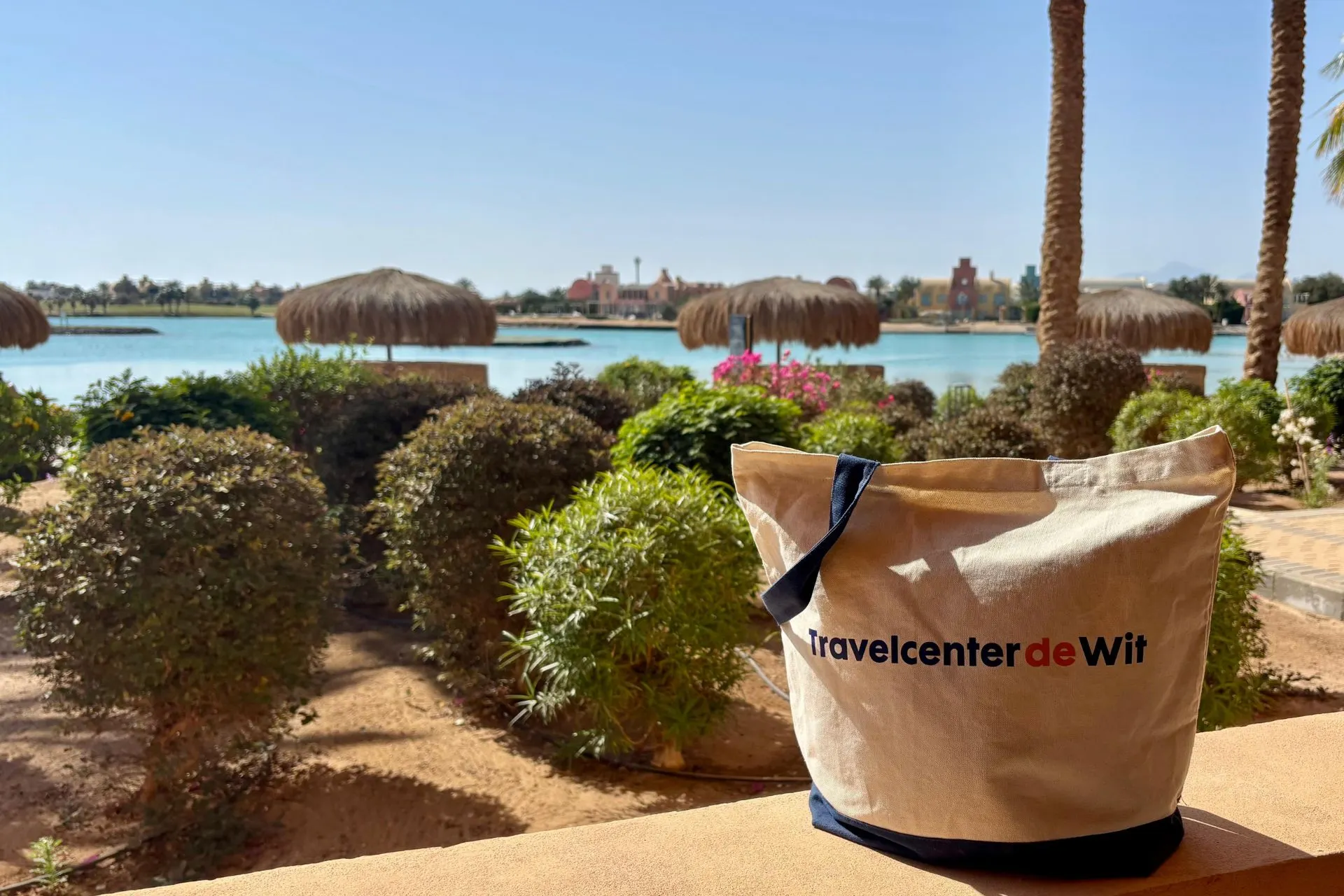 Uitzicht over lagune in El Gouna met Travelcenter de Wit tas op balkon
