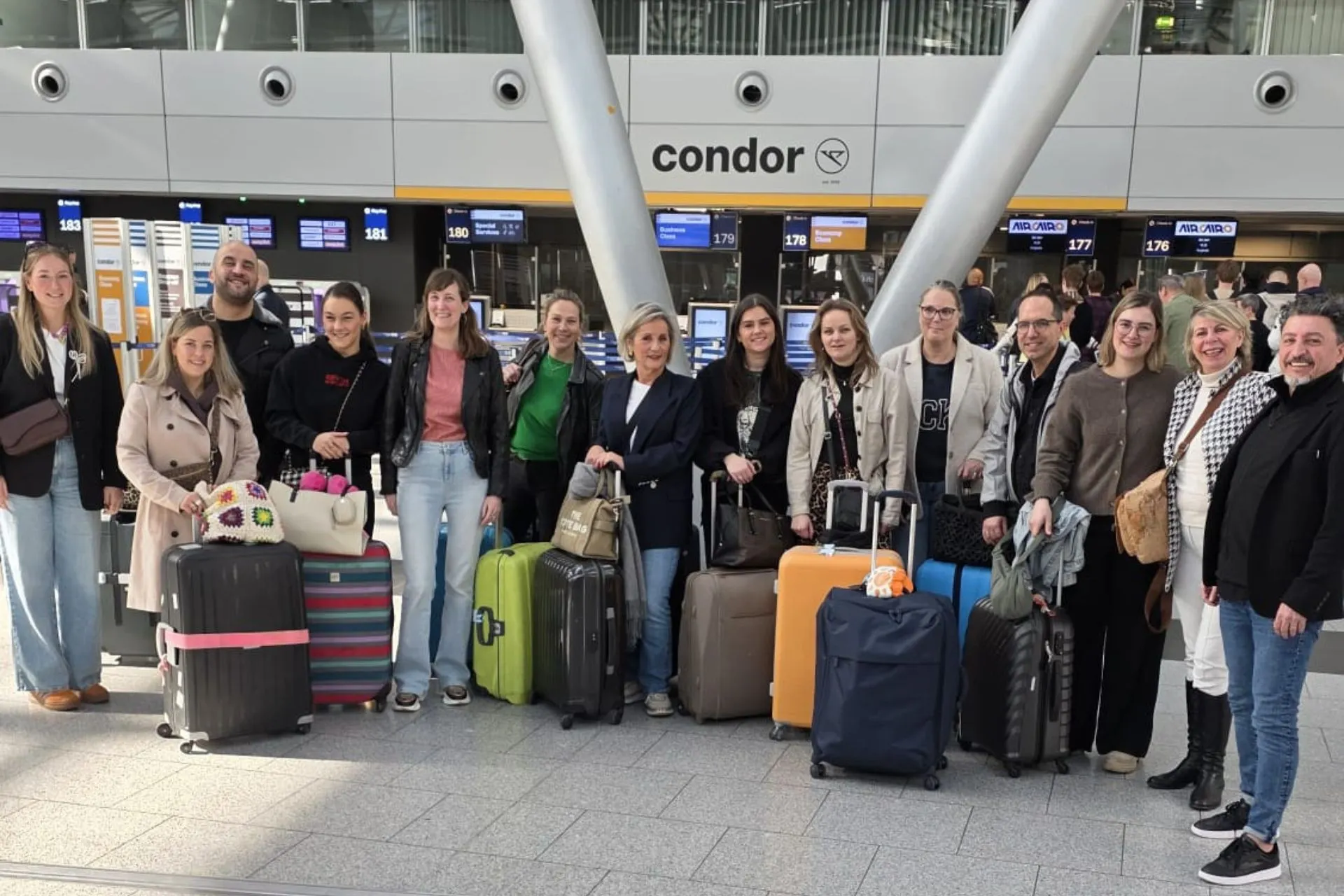 Groep reisagenten met koffers bij de incheckbalies op Düsseldorf Airport voor vertrek naar Egypte
