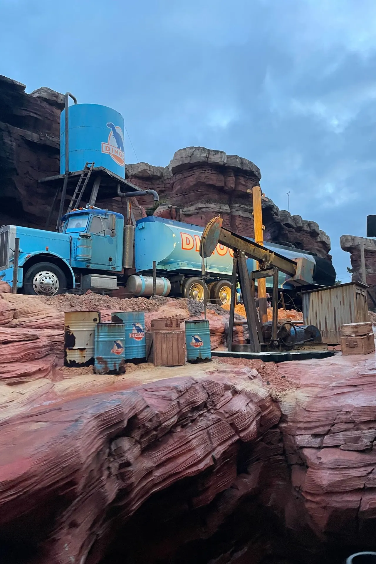 Detail van Cars Route 66 in Walt Disney Studios Park, Disneyland Parijs, met een blauwe truck, benzinetanks en een authentieke woestijnachtige omgeving geïnspireerd op de Pixar-film Cars. Deze attractie brengt de sfeer van Route 66 tot leven en is een favoriet voor fans van Disney en Pixar