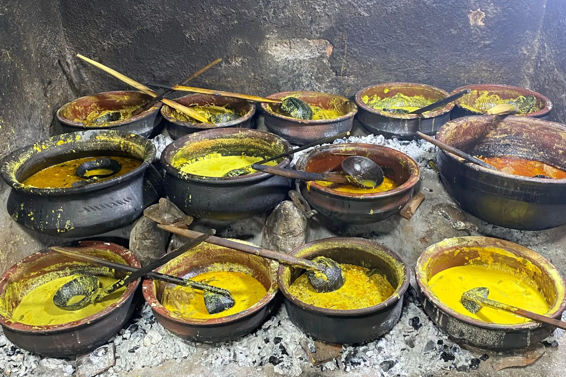 Traditionele aardewerken potten met verschillende curry’s die op houtskool worden verwarmd in Sri Lanka.

