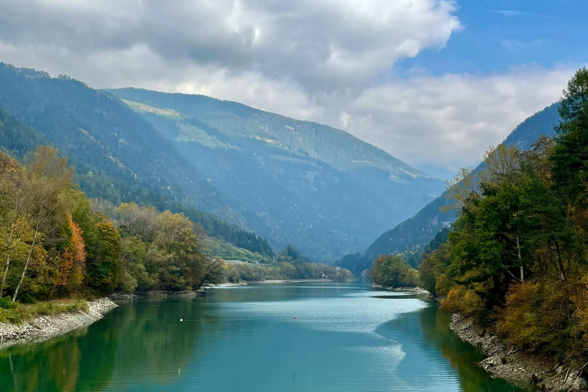 Geniet van een adembenemend uitzicht over een helderblauwe rivier omringd door groene bossen en imposante bergen in Zuid-Tirol. Deze bestemming is ideaal voor wellness reizen en een digital detox vakantie. Ontsnap aan de drukte en ervaar een offline vakantie in Europa, waar rust en natuur centraal staan. Perfect voor slow travel en momenten van pure ontspanning in een serene omgeving.