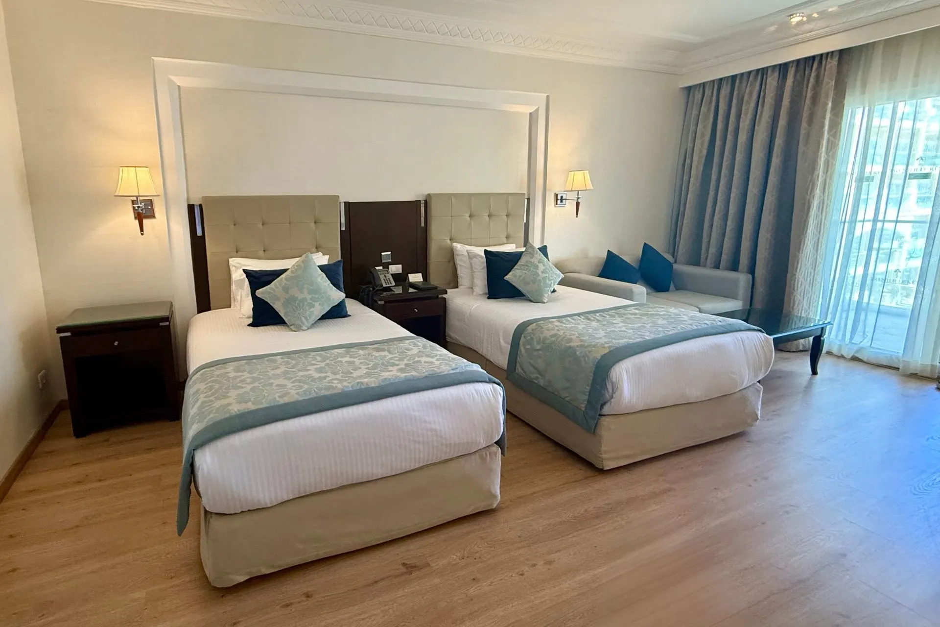 Luxe tweepersoonskamer in Premier Le Reve Hotel & Spa in Egypte met zithoek en balkon.

