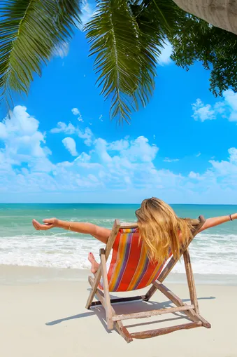 Vrouw op een strandstoel met palmboom