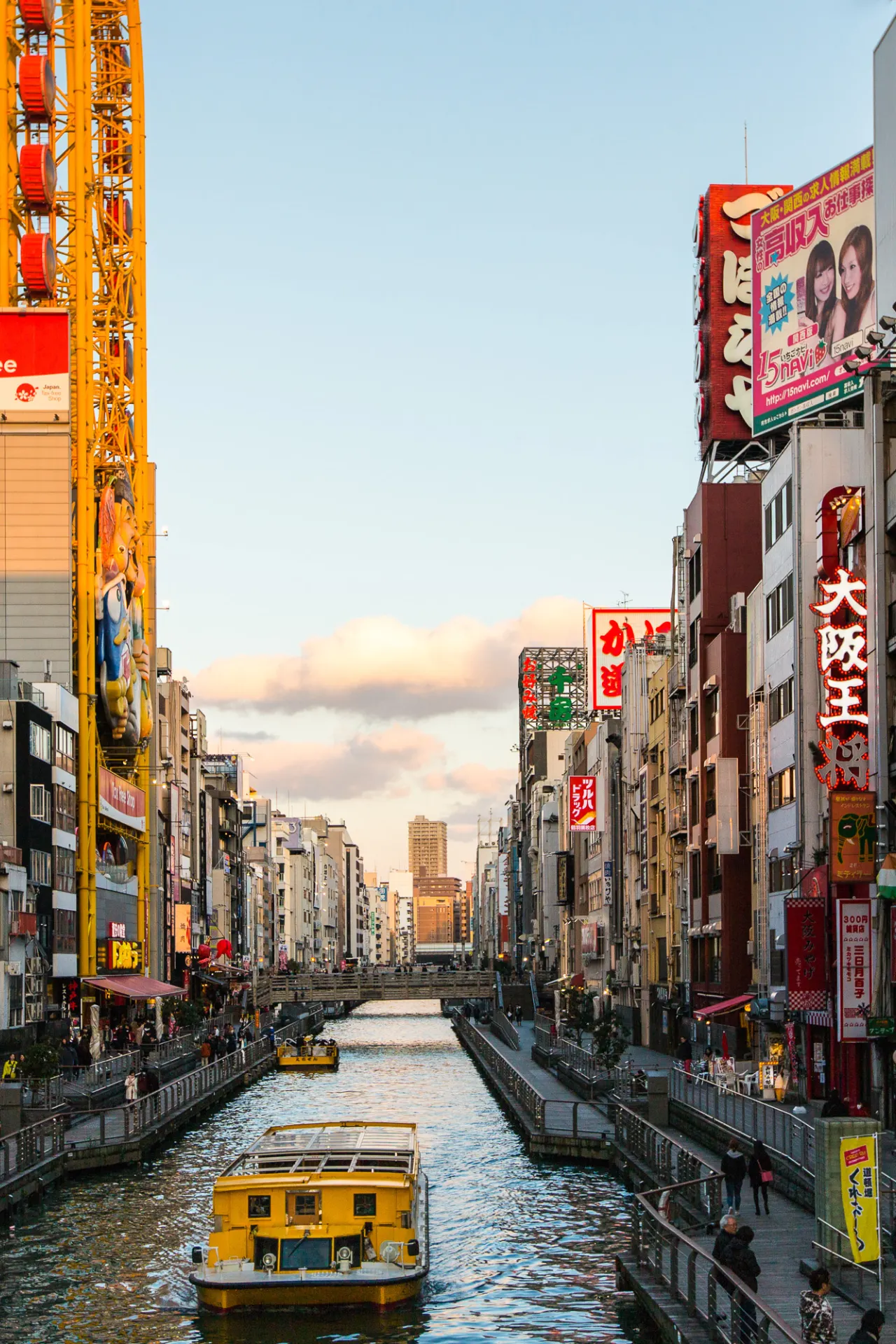 Uitzicht op Osaka, Japan, met een gele boot op een kanaal en gebouwen aan de zijkanten.