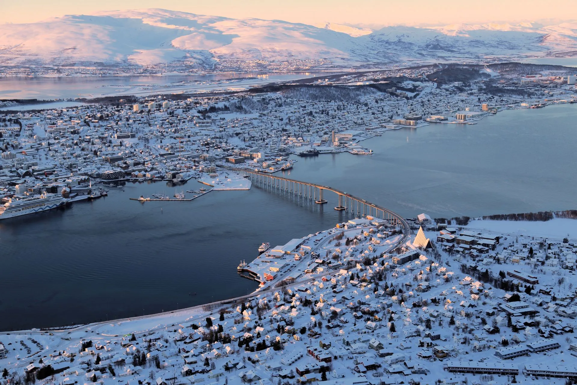 Een schilderachtig Noors stadje bedekt met sneeuw, gelegen aan de oever van een groot bevroren meer, perfect voor een winterreis.