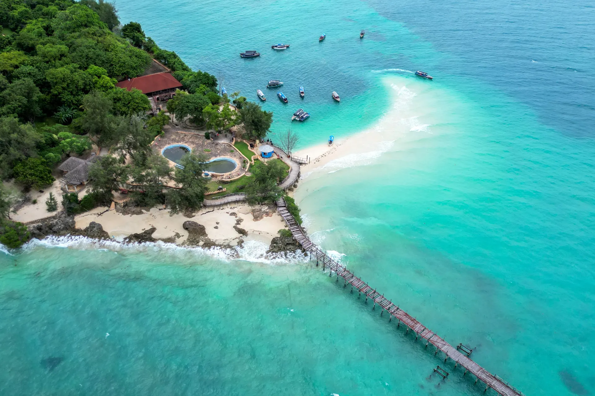 Luchtfoto van Paje Zanzibar met helder turquoise water en een houten loopbrug naar het vaste land.