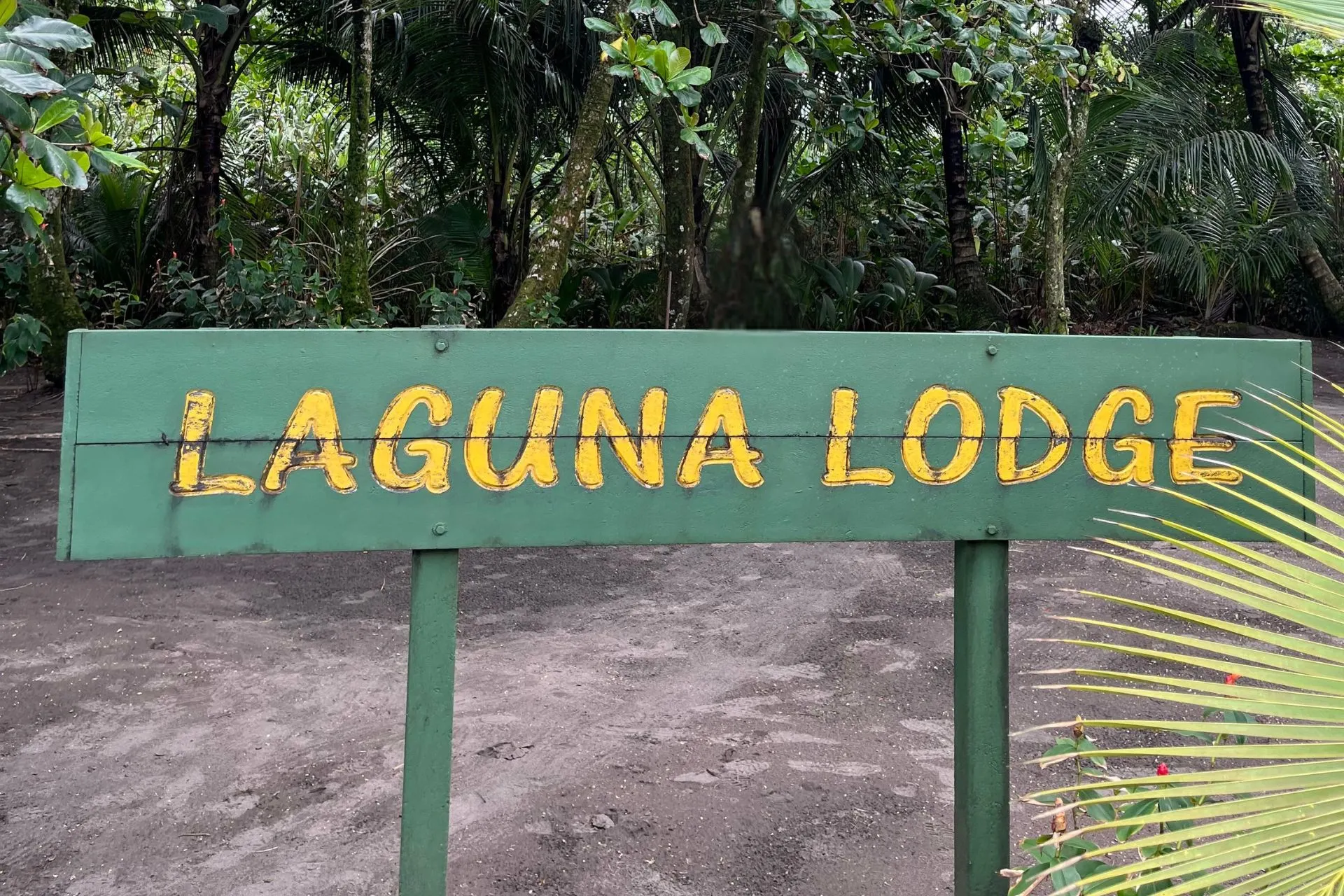 Welkomstbord van Laguna Lodge in Tortuguero, Costa Rica. Deze sfeervolle lodge ligt midden in de tropische natuur van Tortuguero National Park en vormt een ideale uitvalsbasis voor bootexcursies en wildlife-ervaringen.