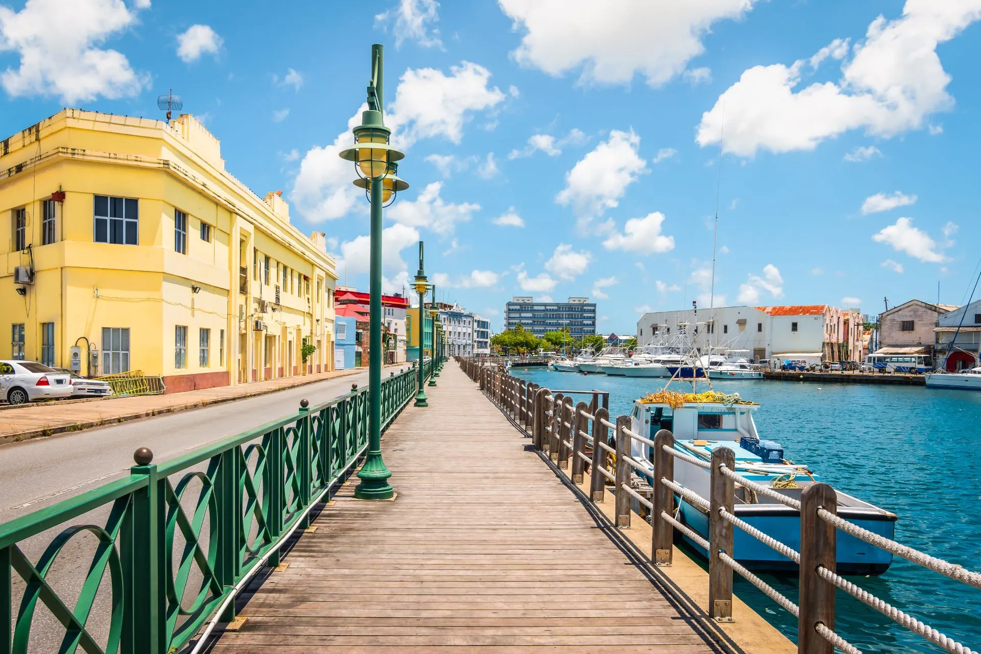 Een charmant stadje in Barbados met kleurrijke huisjes langs het water, omringd door een tropische sfeer en helderblauw zeewater.