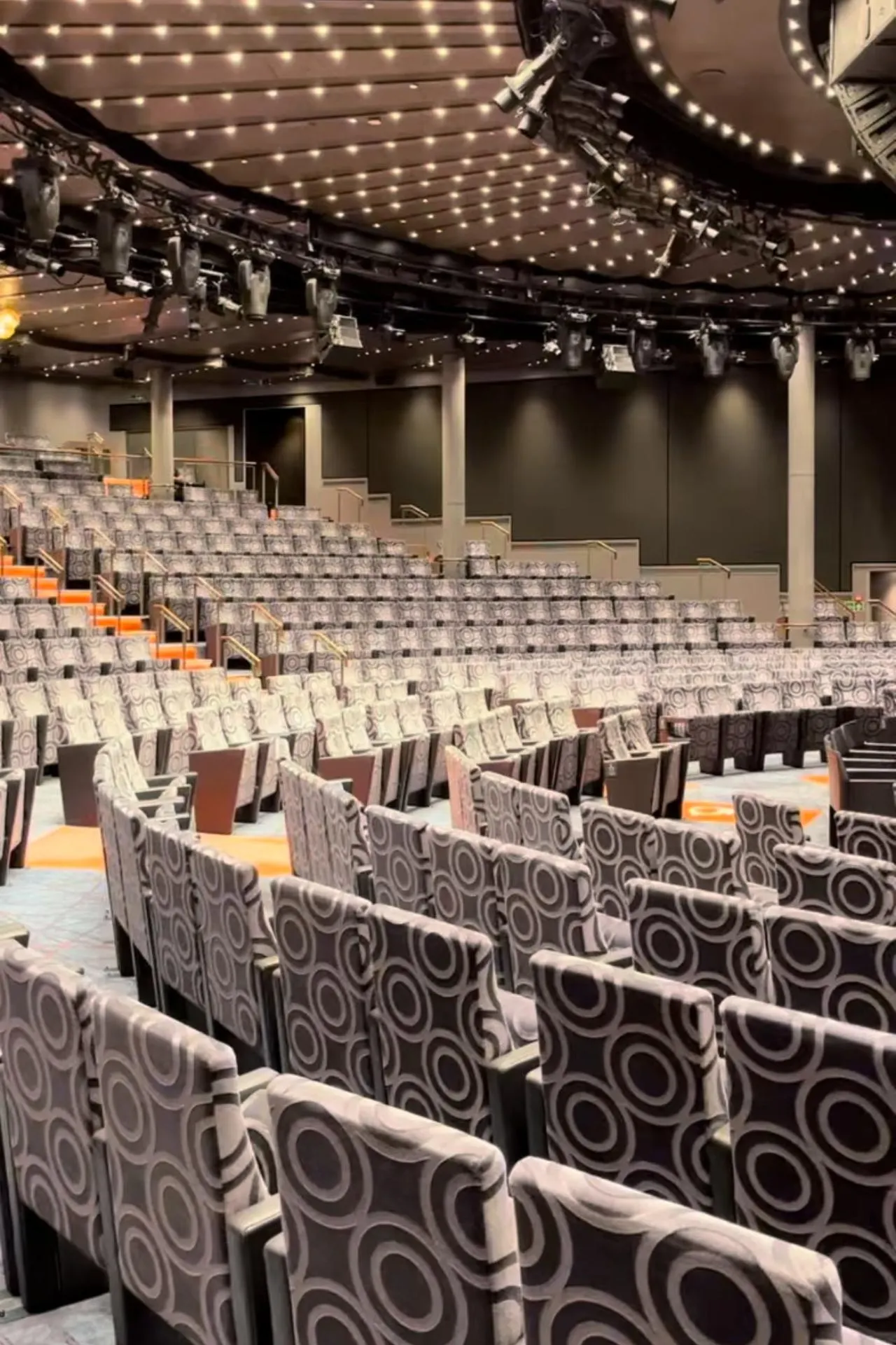 Het moderne theater aan boord van de Nieuw Statendam, met comfortabele zitplaatsen en een indrukwekkend plafond vol verlichting.
