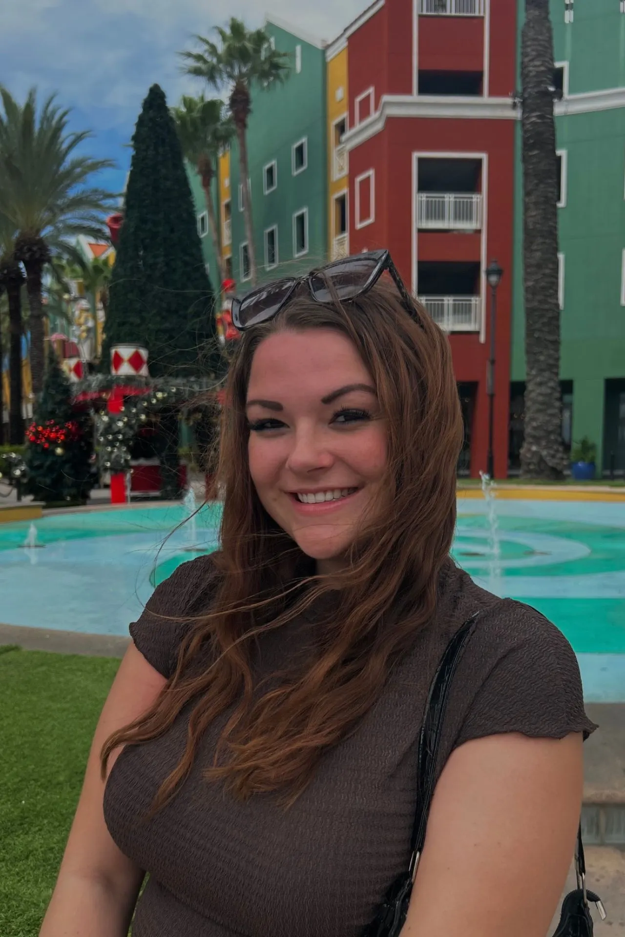 Kleurrijke gebouwen in Willemstad op Curaçao met palmbomen en een fontein op de voorgrond. Dit typerende straatbeeld laat de levendige sfeer en unieke uitstraling van het eiland zien.
