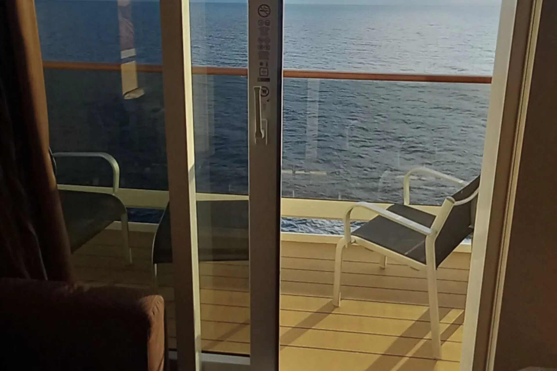 Uitzicht op de oceaan vanaf het balkon van een hut op een MSC Cruises schip, met twee stoelen op het balkon.