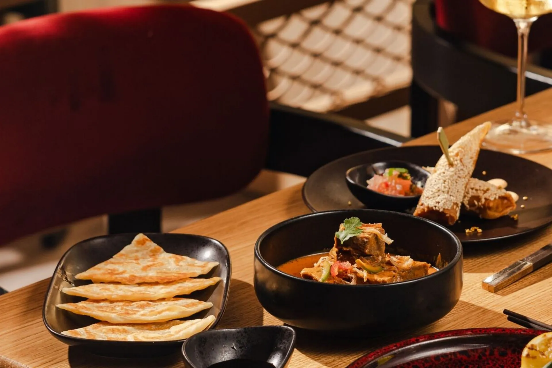 Culinair diner op een Explora cruise met aromatische curry, mals vlees, flatbread en verfijnde bijgerechten, geserveerd in een stijlvolle Explora dining omgeving. Ontdek gastronomische creaties tijdens jouw reis met Explora Journeys en ervaar de luxe van Explora suites op Explora I of Explora II. Perfect voor gasten die Explora boeken en op zoek zijn naar een unieke fine dining ervaring op zee.