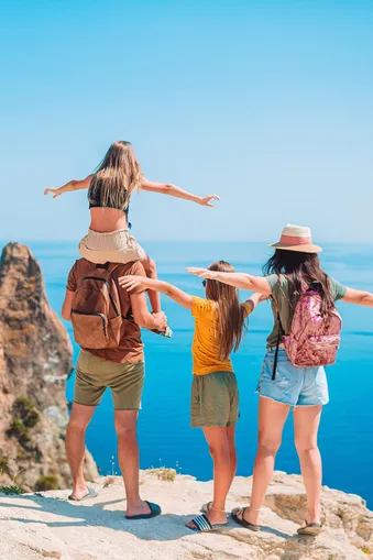 Foto gezin op rots met zee op achtergrond