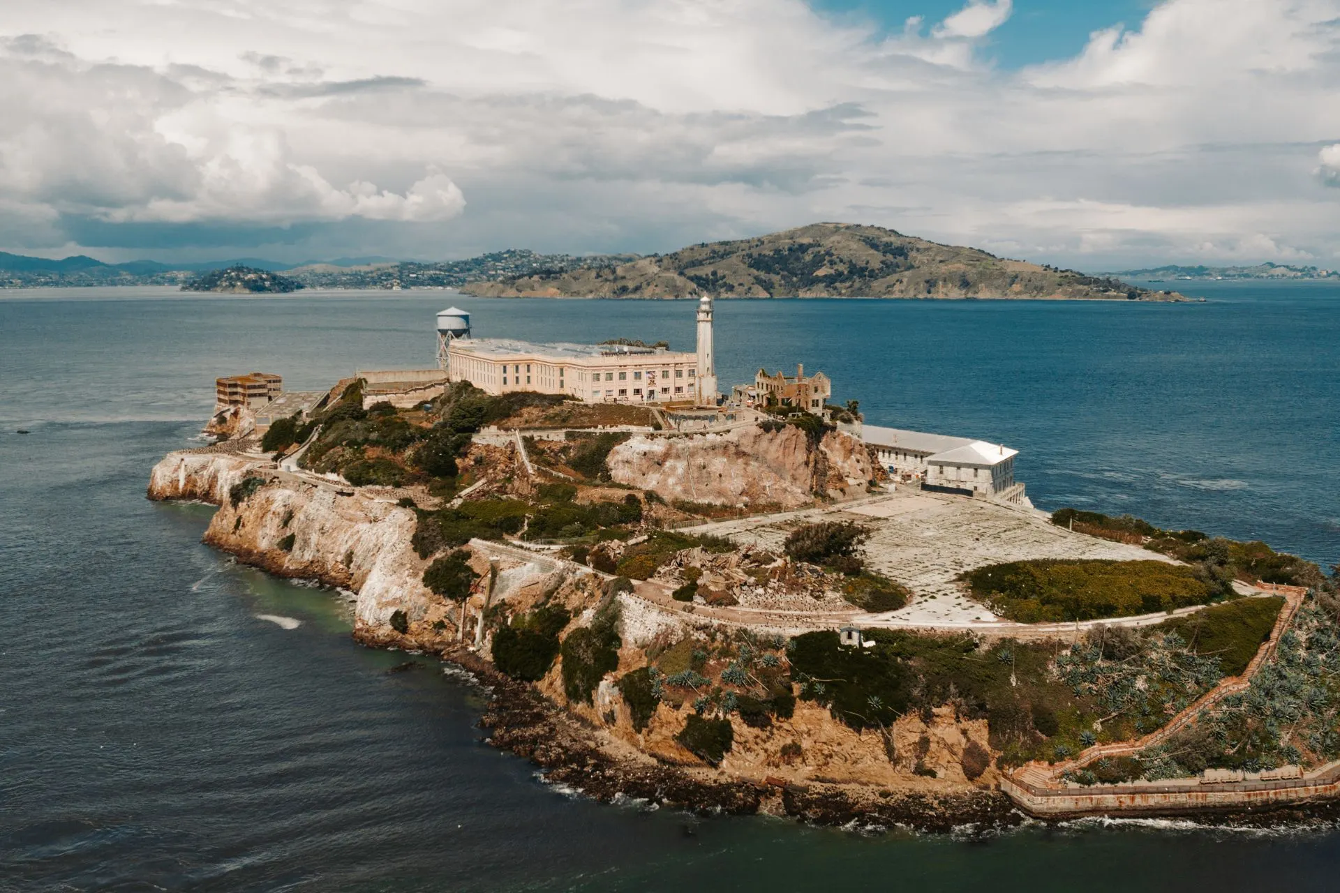 Luchtfoto van Alcatraz Island met het historische gevangeniscomplex, omringd door San Francisco Bay en heuvelachtig landschap.