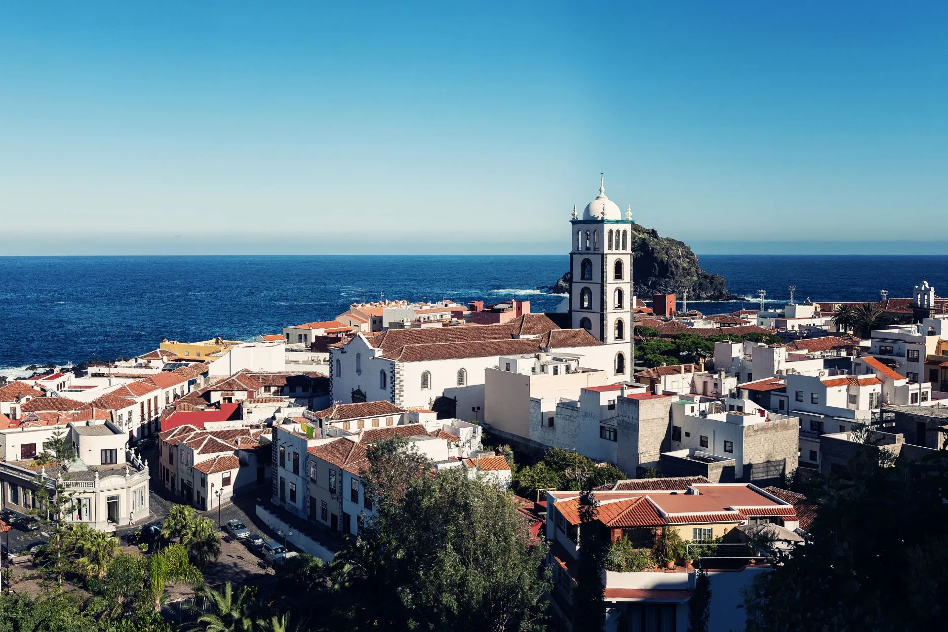 Uitzicht over Garachico in Noord-Tenerife met de karakteristieke kerk en de Atlantische Oceaan op de achtergrond.