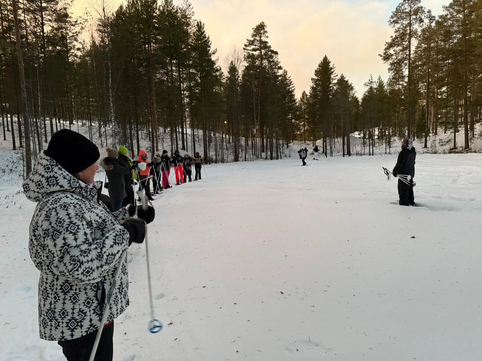 Sneeuwschoen safari in Finland, je ziet een aantal mensen op een rijtje met stokken in de hand.