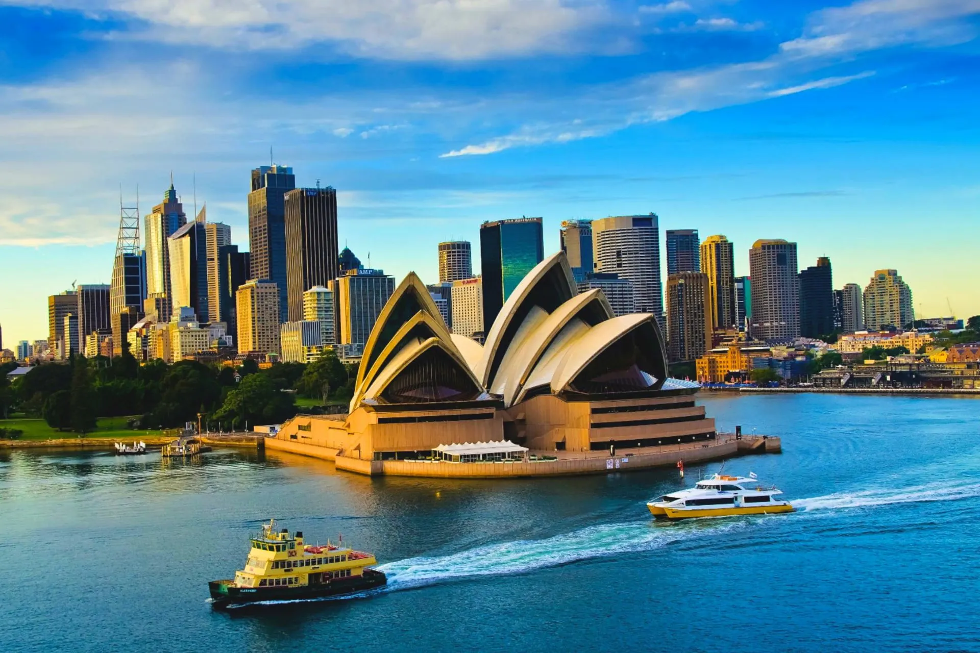 Iconisch modern gebouw aan het water met skyline van Sydney en passerende veerboten in Australië