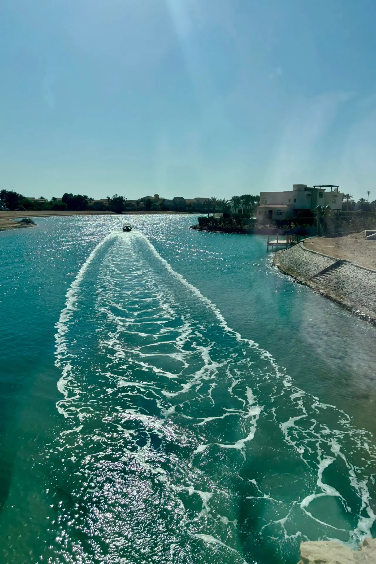 Privéboot laat een vaarspoor achter in de turquoise lagunes van El Gouna in Egypte.
