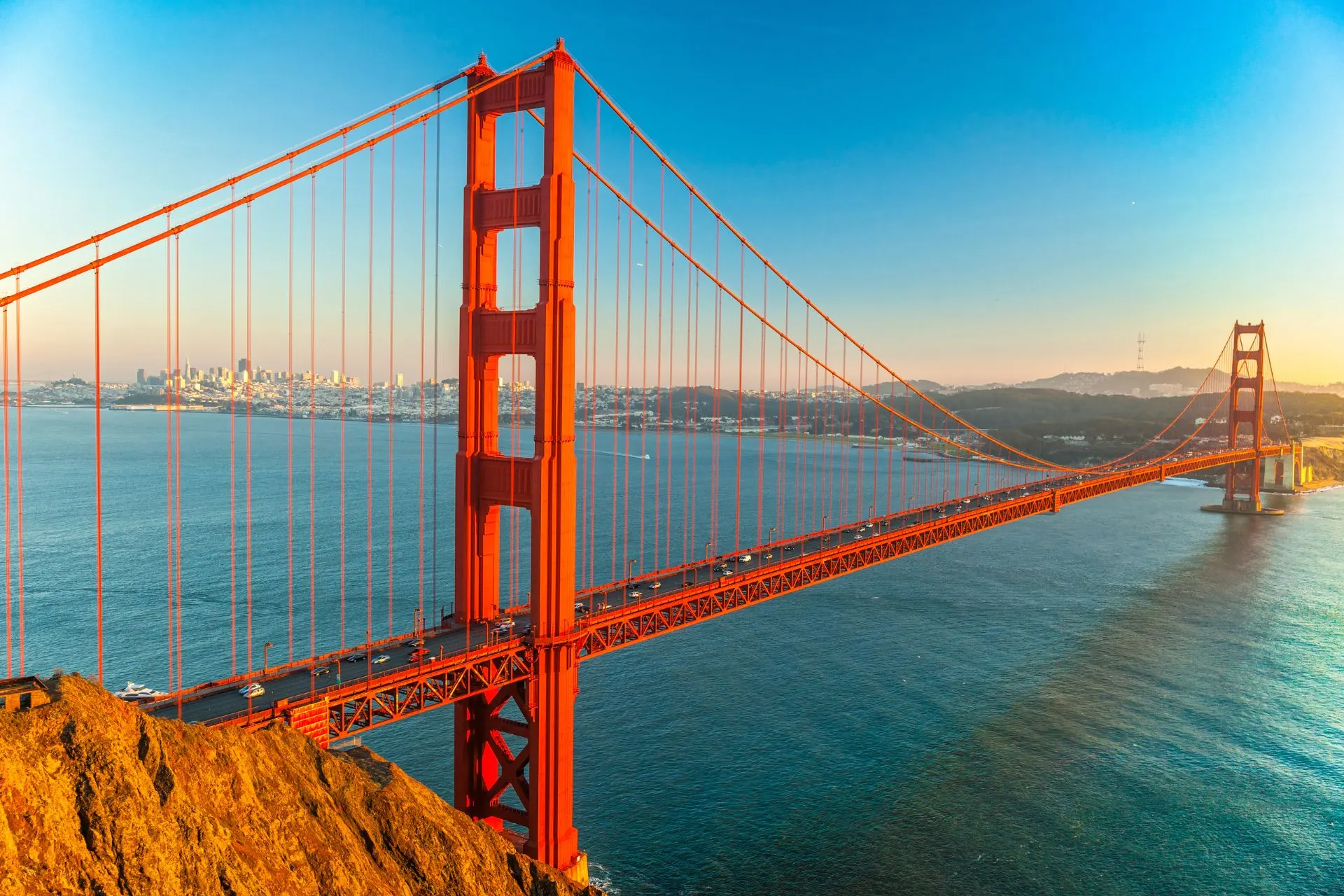 De beroemde Golden Gate Bridge in Californië, gekleed in helder rood, met de mistige oceaan op de achtergrond.