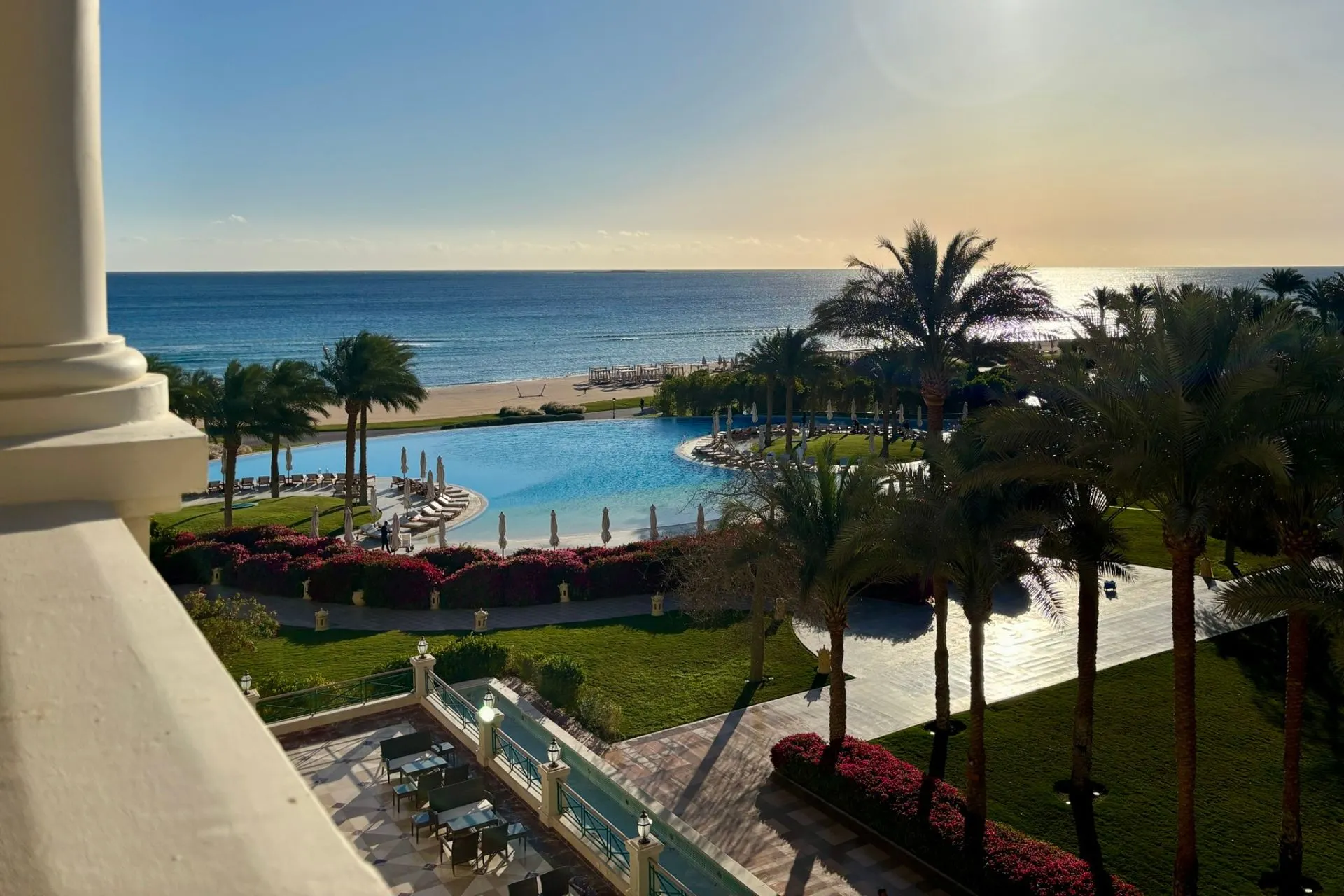 Uitzicht over zwembad, palmbomen en strand bij een resort aan de Rode Zee in Egypte tijdens een studiereis