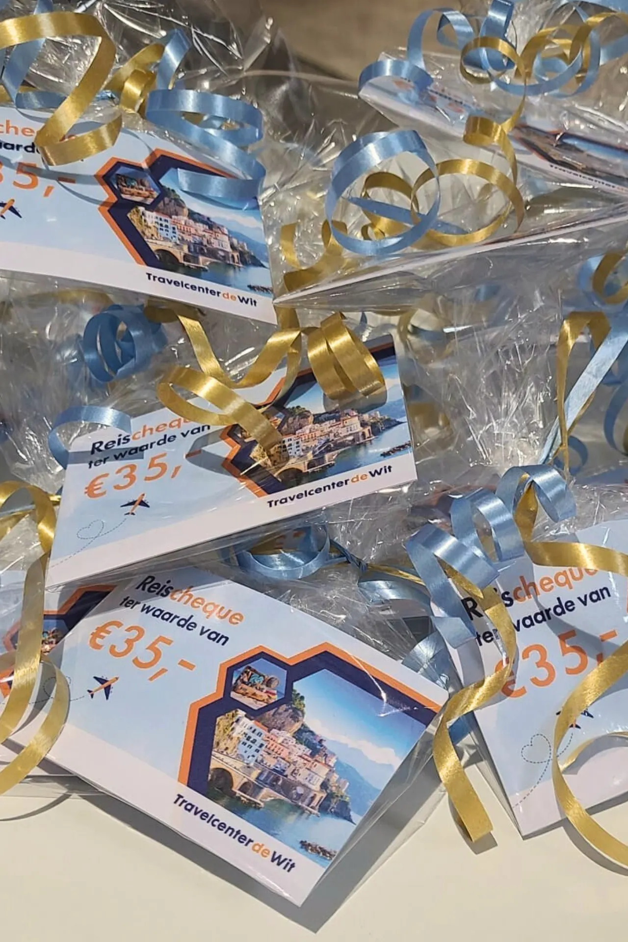 Reischeques feestelijk ingepakt in doorzichtig folie met gekleurd gekruld lint, klaargelegd voor de deelnemers van het websiteonderzoek.