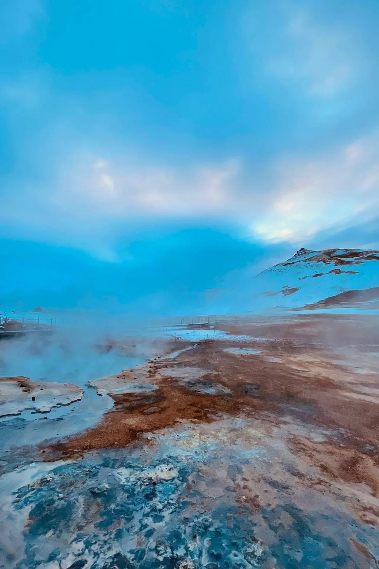 Geothermisch landschap nabij Myvatn in Noord‑IJsland met stoompluimen en kleurrijke aarde in winterse omstandigheden.