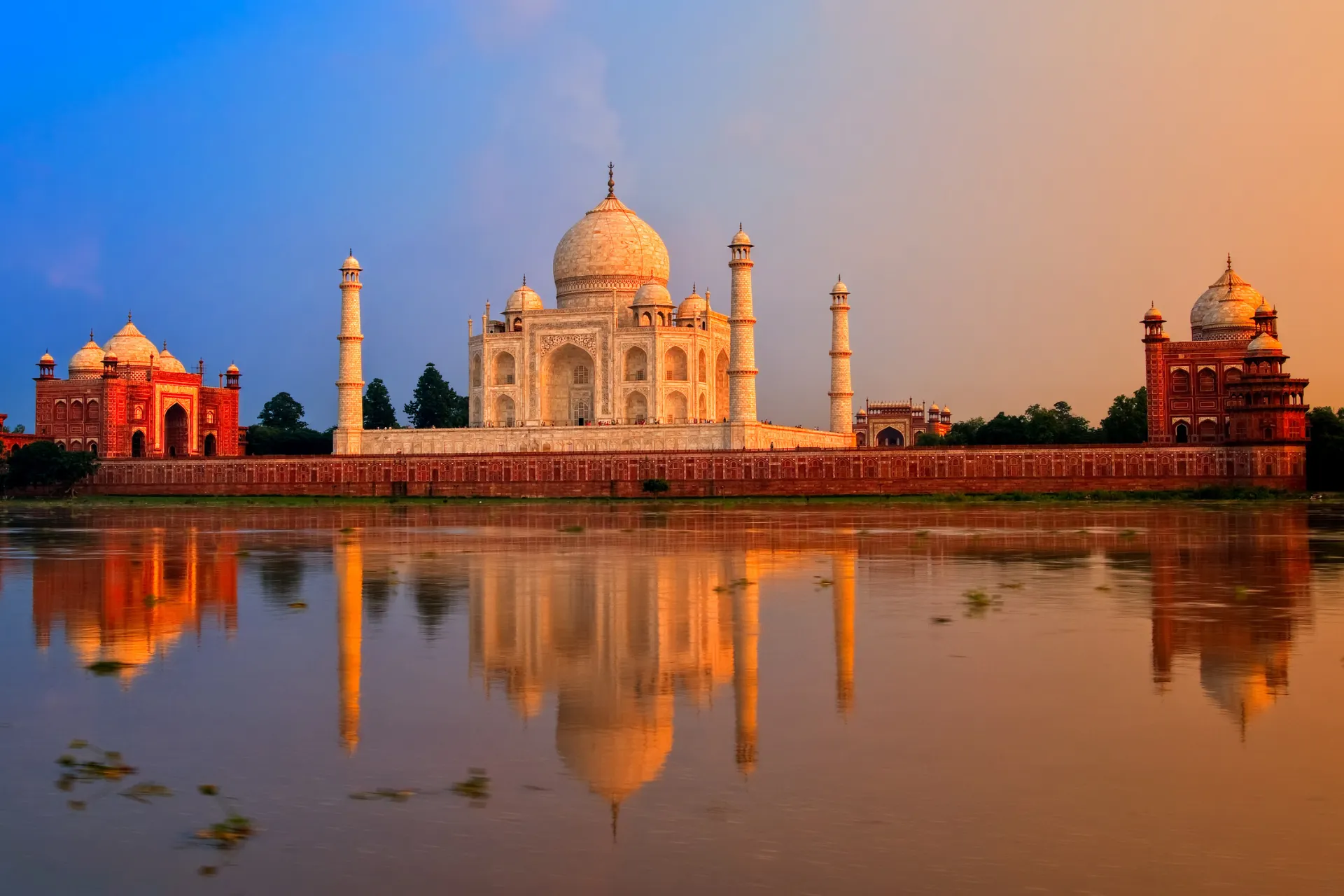 De Taj Mahal in India tijdens zonsondergang, weerspiegeld in de rivier Yamuna. Een iconisch UNESCO-werelderfgoed en een van de mooiste bezienswaardigheden van India.