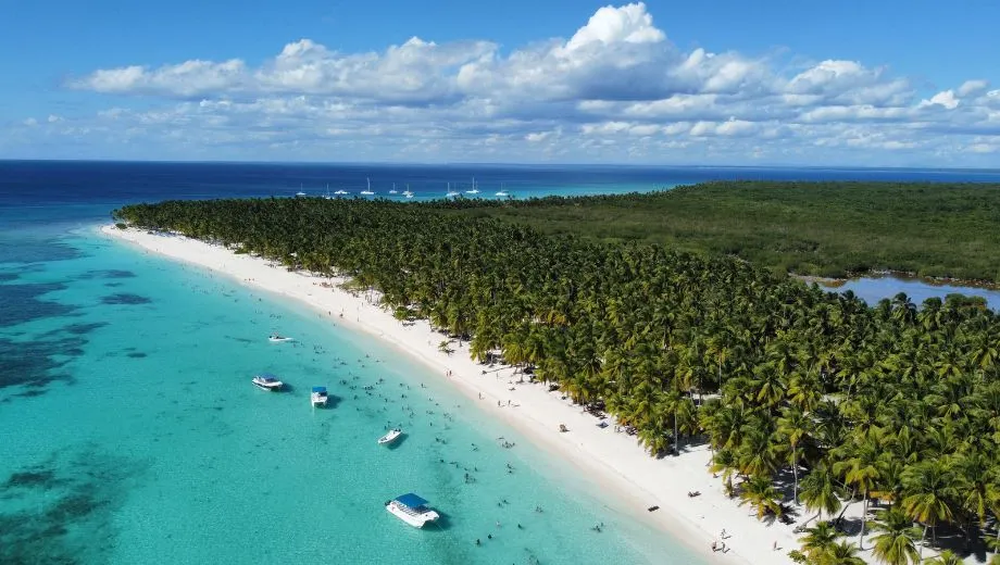 Oostkust van de Dominicaanse Republiek met een azuurblauwe zee, palmbomen en een tropisch kustlandschap.