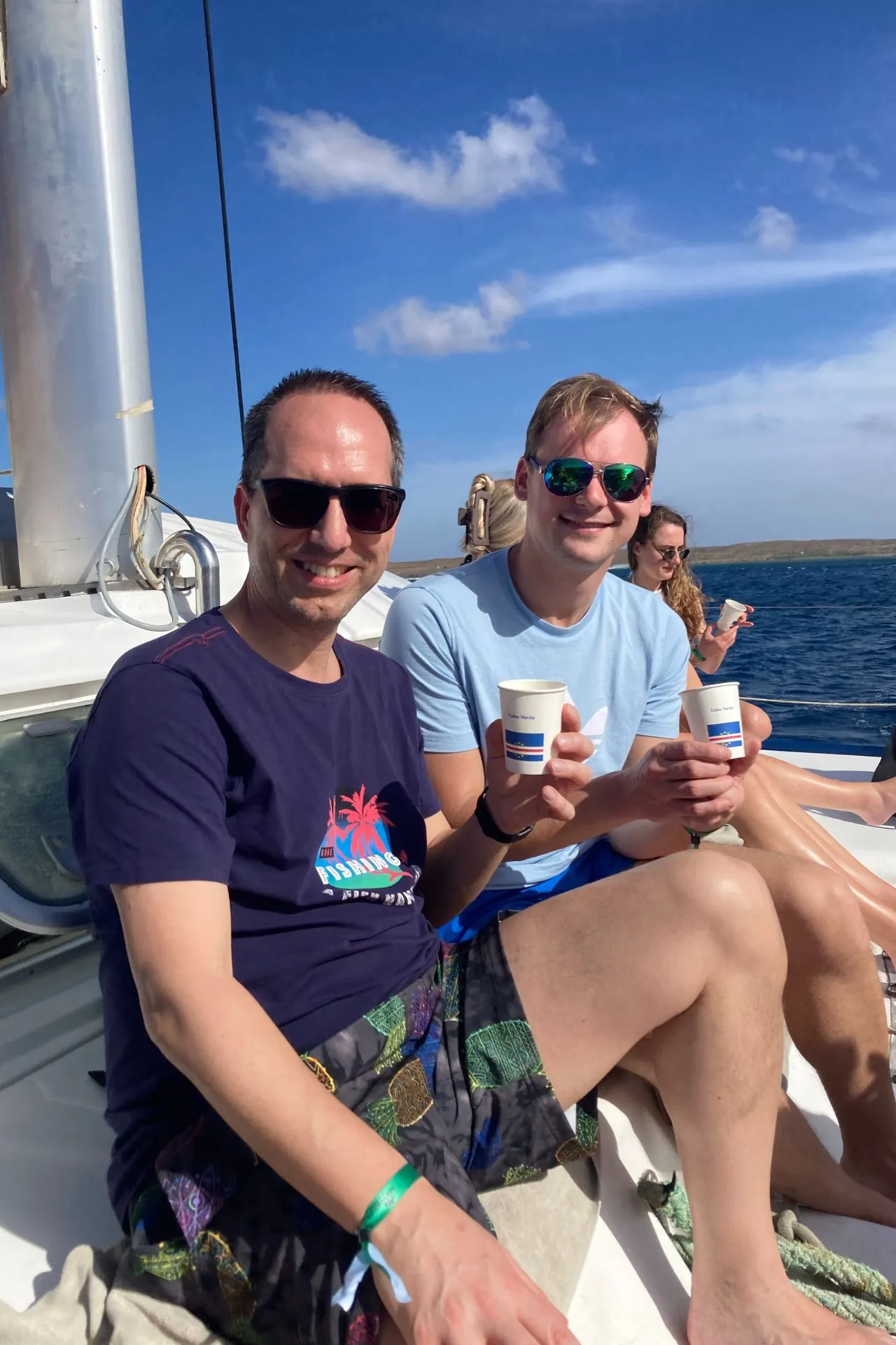 Boottocht langs de kust van Kaapverdië waarbij reizigers ontspannen zitten met uitzicht op zee, rotsachtige eilanden en een heldere blauwe lucht. Deze ervaring sluit naadloos aan bij een vakantie Kaapverdië waarin zee en ontspanning centraal staan. Voor liefhebbers van een excursie Kaapverdië of dagtocht op het water benadrukt dit beeld hoe boottochten en zeetrips een vast onderdeel zijn van het eilandleven en de reisbeleving.