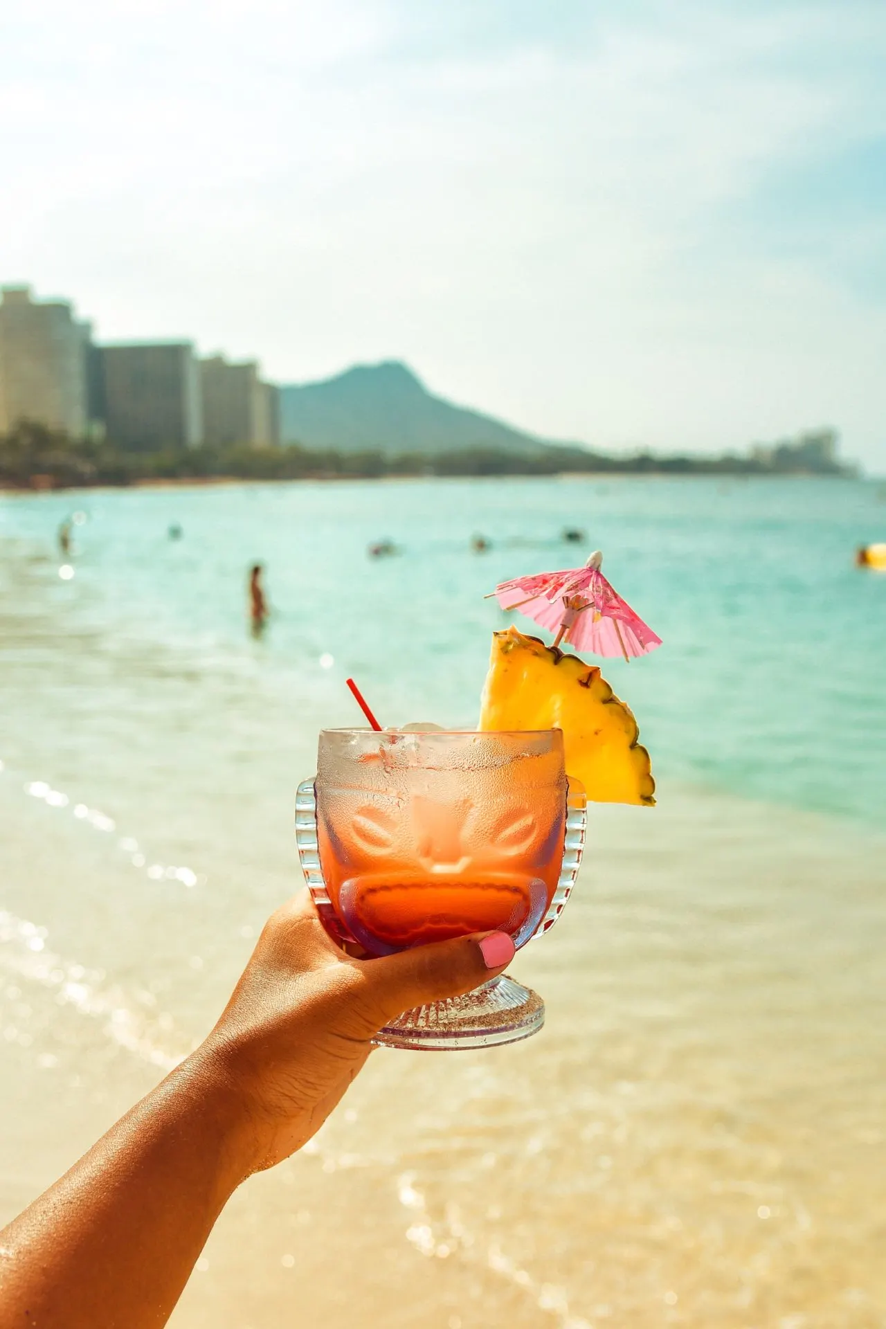 Kleurrijke cocktail met vers fruit op een tropisch strand in Jamaica, met de zee op de achtergrond.