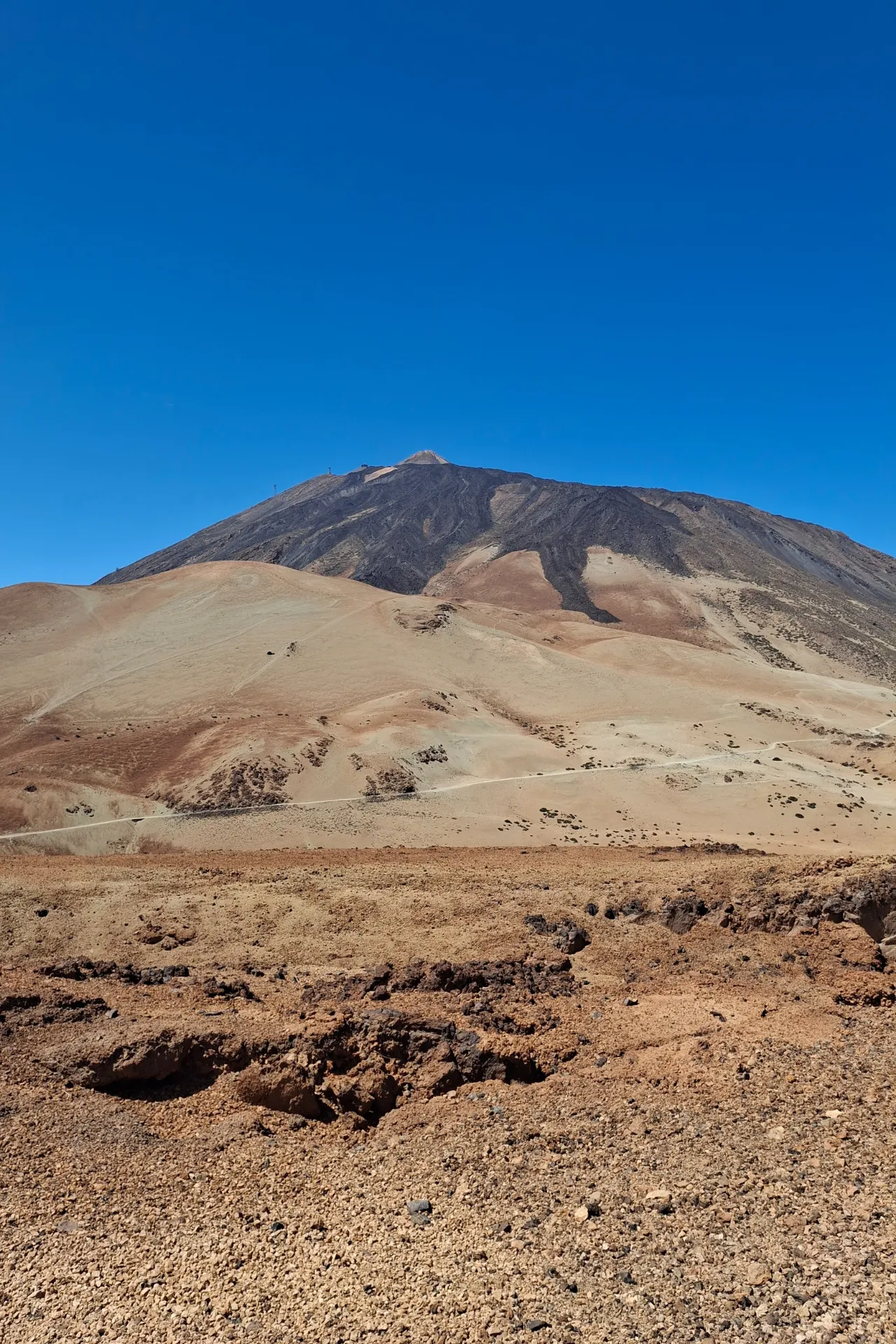 De imposante Teide vulkaan onder een heldere blauwe lucht, het iconische landschap van Tenerife.