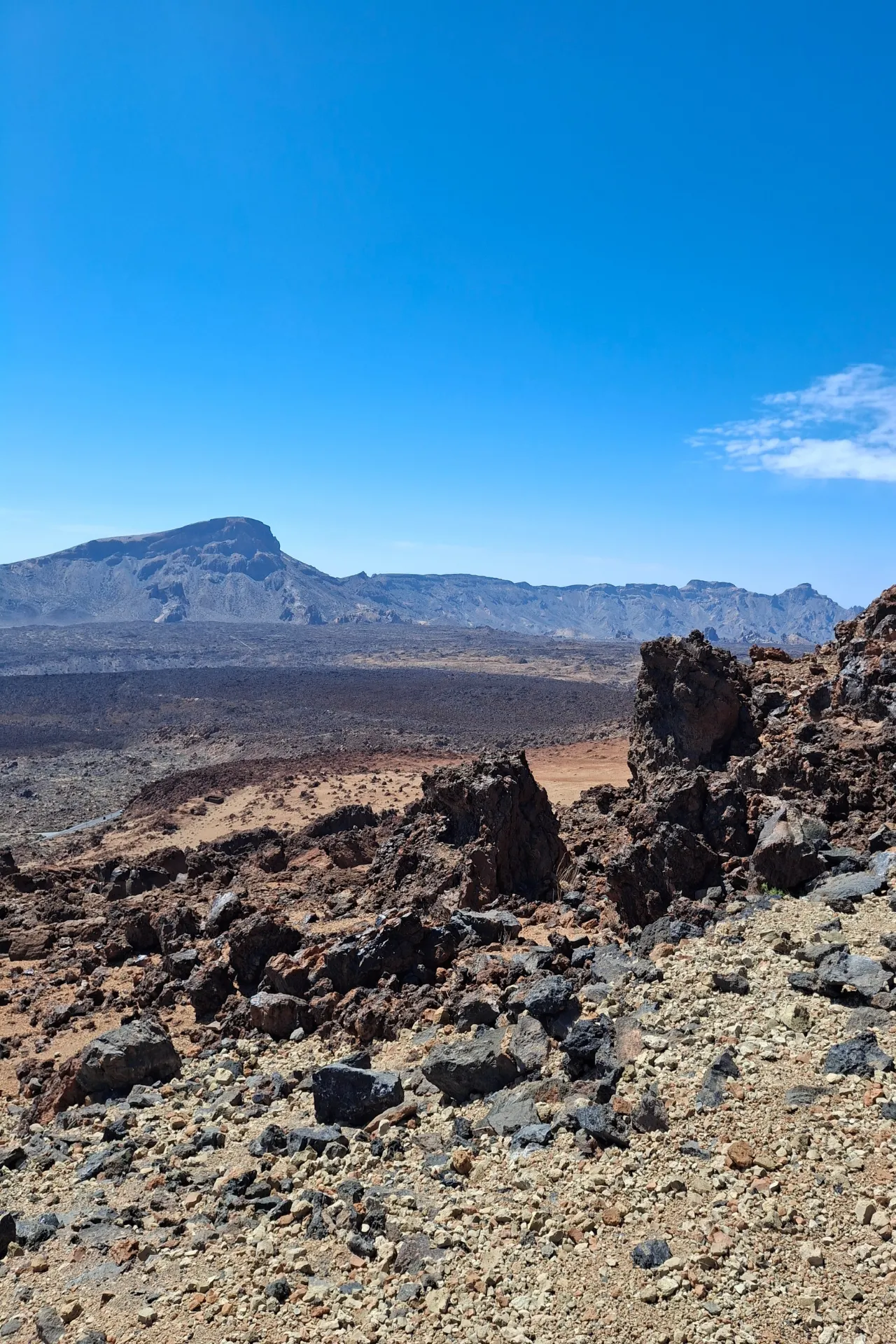 Teide vulkaan met een uitgestrekt zandlandschap en een heldere blauwe lucht op Tenerife.