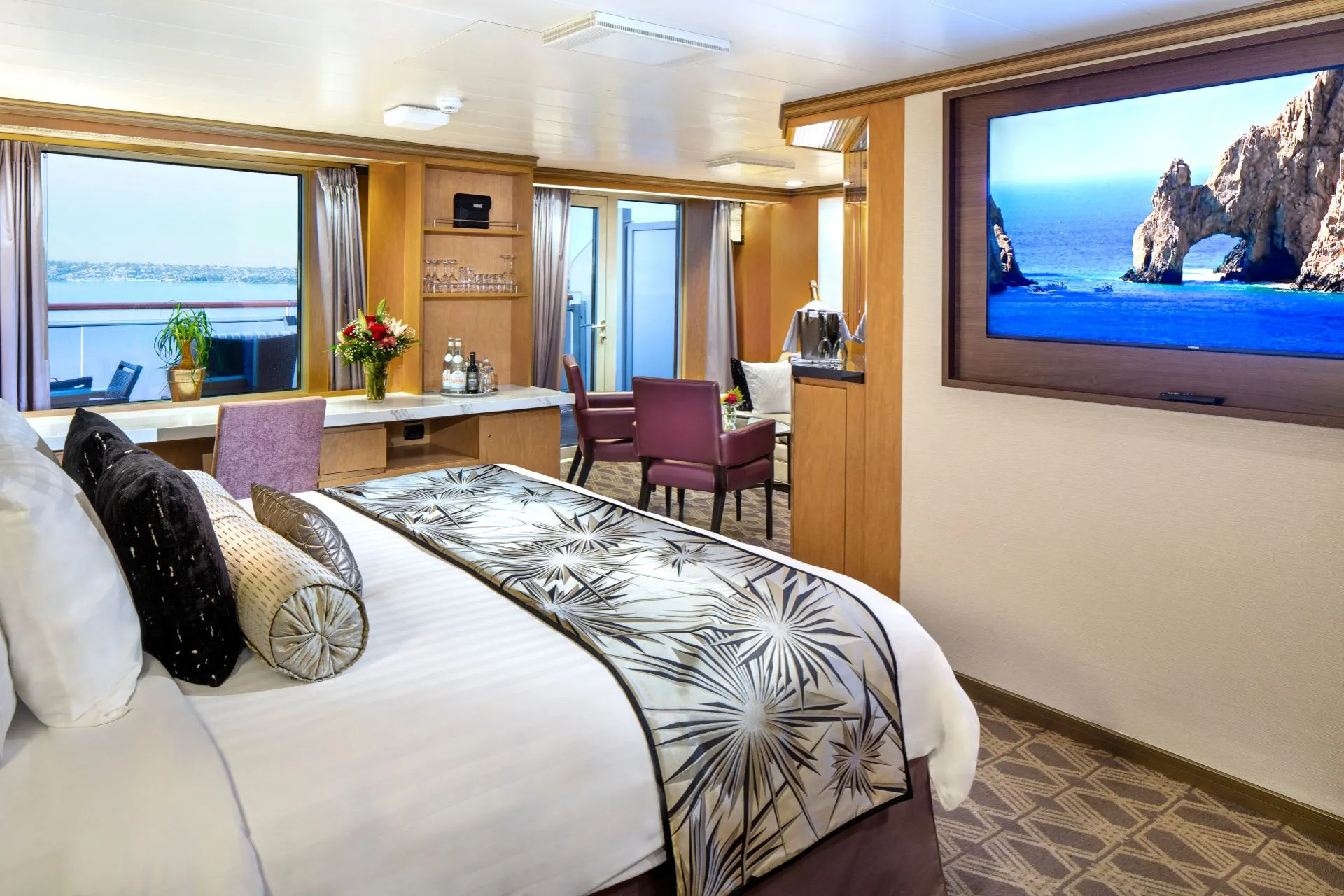 Ruime Neptune Suite van Holland America Line met kingsize bed, luxe afwerking en balkon – ultiem comfort op zee.