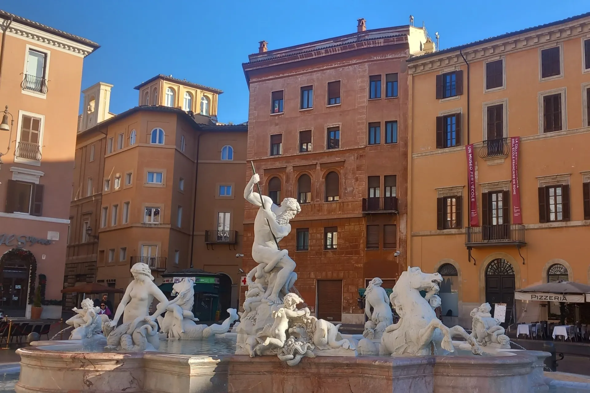 Een beeld van de Neptunusfontein op Piazza Navona in Rome, omringd door historische gebouwen.