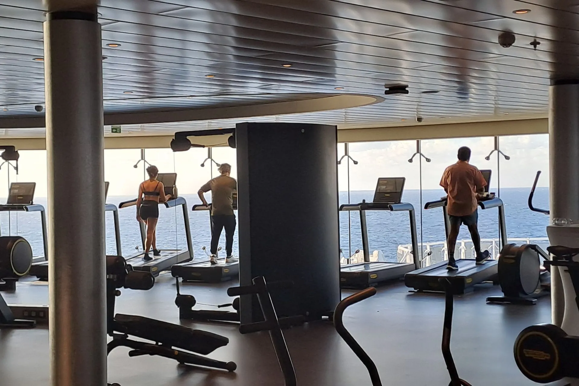Moderne sportschool op een MSC Cruises schip met loopbanden die uitkijken over de eindeloze zee.