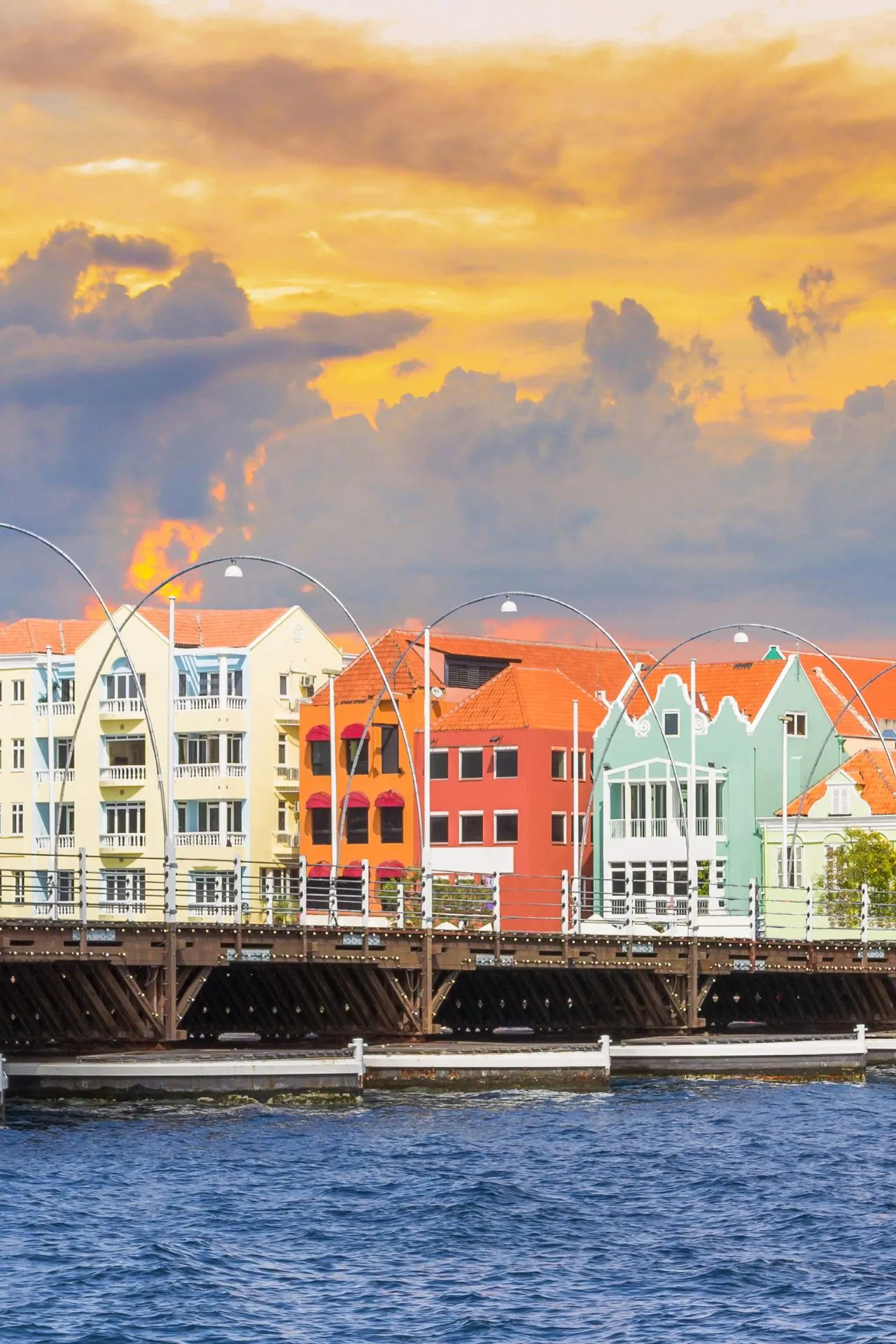 Kleurrijke gebouwen langs het water in Willemstad op Curaçao met de bekende brug op de voorgrond. Dit iconische beeld laat de levendige sfeer en unieke uitstraling van het eiland zien.