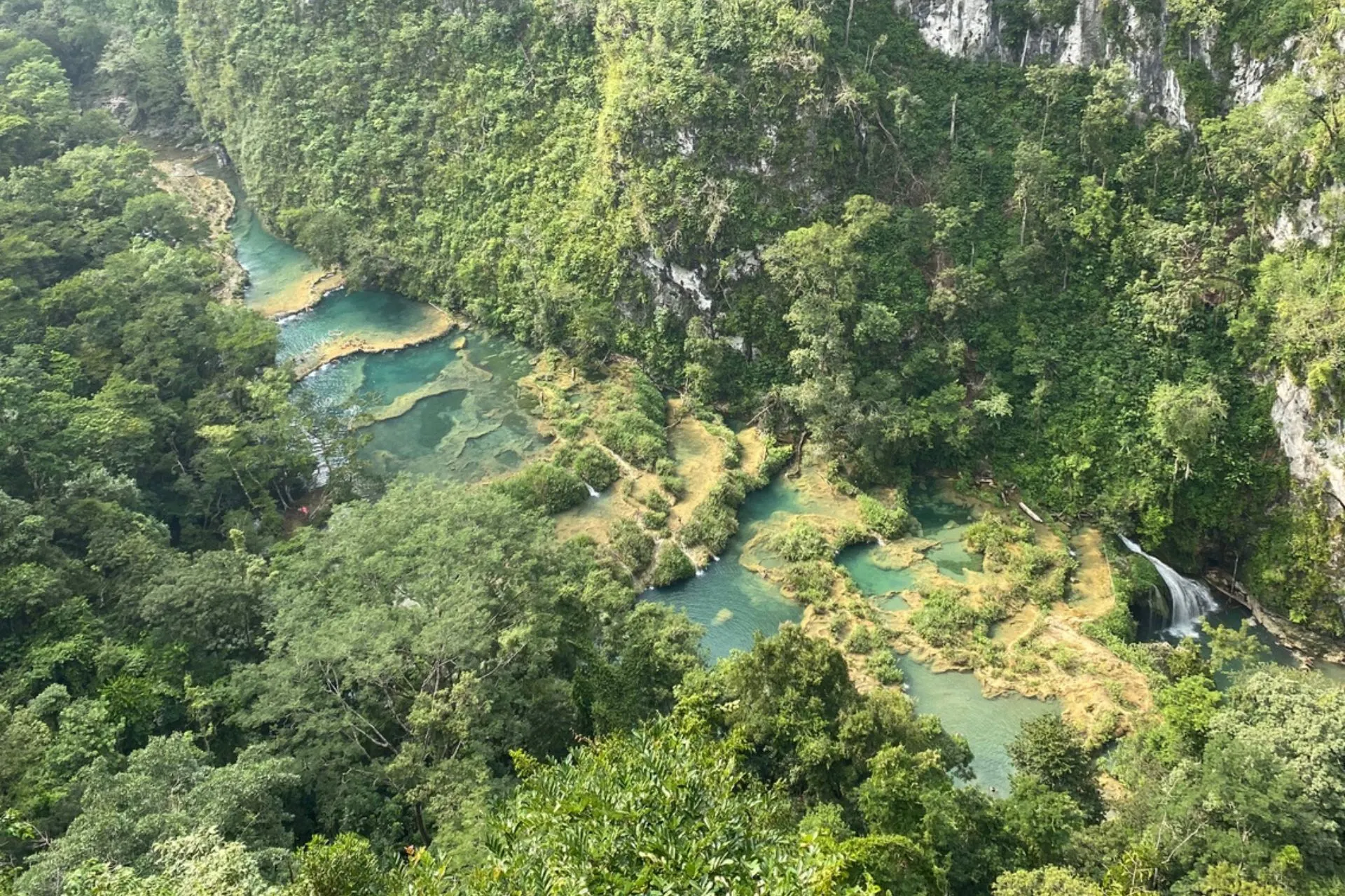 Overzicht van de kalkstenen terrassen en turquoise baden van Semuc Champey, diep in de jungle van Guatemala.