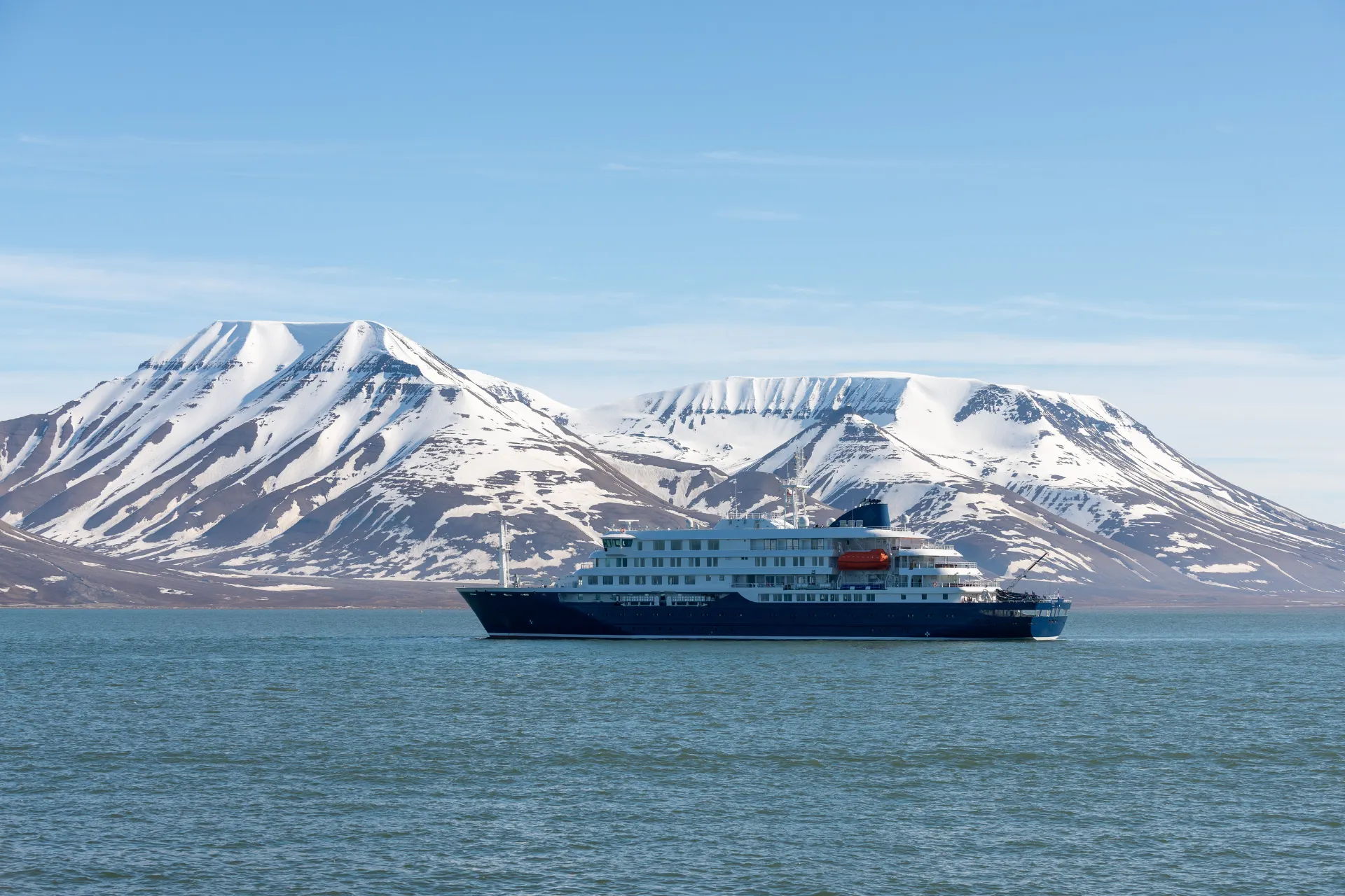 Hapag Lloyd cruiseship vaart majestueus langs indrukwekkende, met ijs bedekte bergen in Antarctica.
