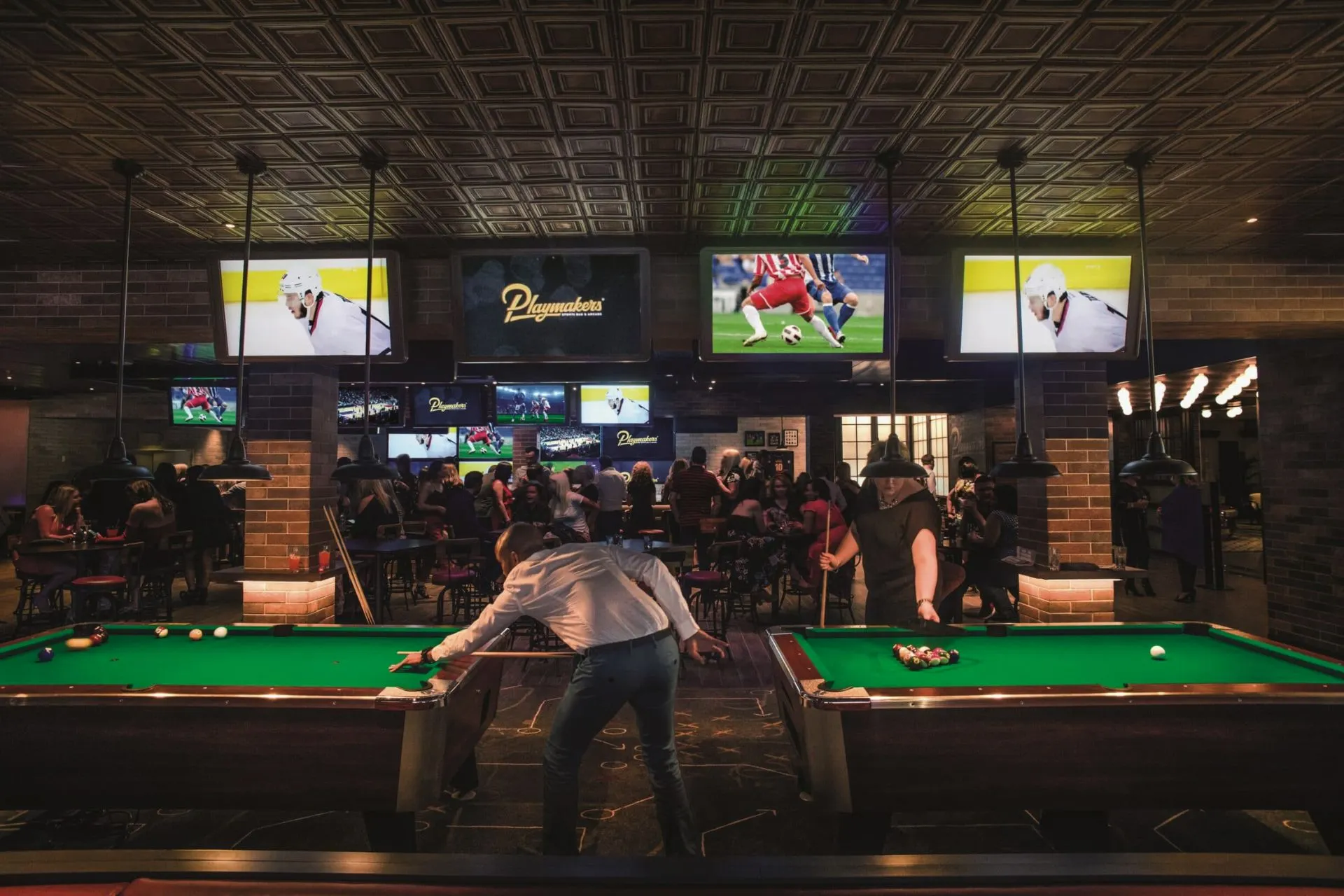 Playmakers Sports Bar & Arcade op de Independence of the Seas, met gasten die pool spelen, meerdere televisieschermen met sportwedstrijden en een levendige sfeer.