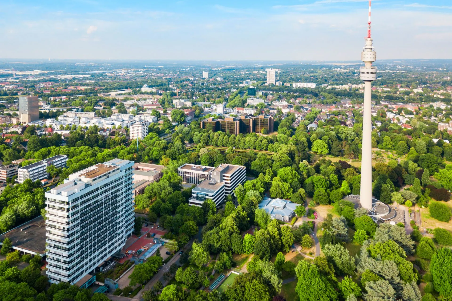 Groen stadslandschap met de iconische Florian Tower in Dortmund. Veel reizigers kiezen ervoor om te vliegen vanaf Dortmund vanwege de gunstige verbindingen en goedkope vluchten vanaf Dortmund Airport naar diverse Europese bestemmingen.