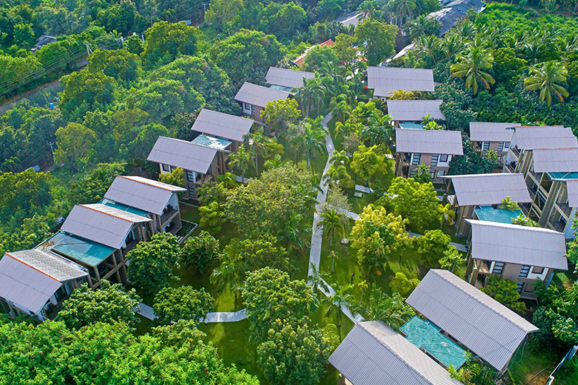 Luchtfoto van de moderne villa’s van Chaarya Resort & Spa Yala, verspreid tussen tropische bomen en verbonden via wandelpaden, met privéterrassen en weelderige begroeiing.