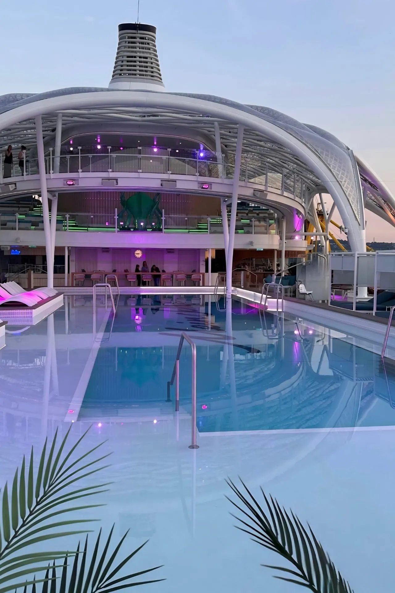 Het zwembaddek van de Mein Schiff Flow is sfeervol verlicht tijdens de avonduren. Het moderne ontwerp met zwembad, ligbedden, lounges en overdekte gedeeltes laat zien hoeveel aandacht er aan comfort en ontspanning is besteed. Overdag is dit een populaire plek om te zwemmen en zonnen, terwijl het dek ’s avonds een rustige en luxe uitstraling krijgt.