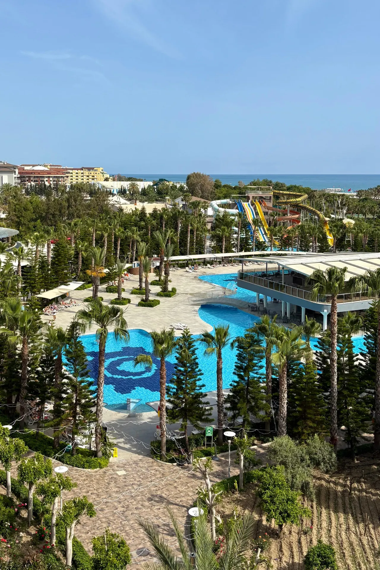 Panoramisch uitzicht over Sunmelia Beach Resort in Kizilagac nabij Side, met grote zwembaden, palmbomen, zonneterrassen en het aquapark op de achtergrond. De ligging vlak bij het strand en de uitgebreide faciliteiten maken dit resort een populaire keuze voor een vakantie aan de Turkse Rivièra.
