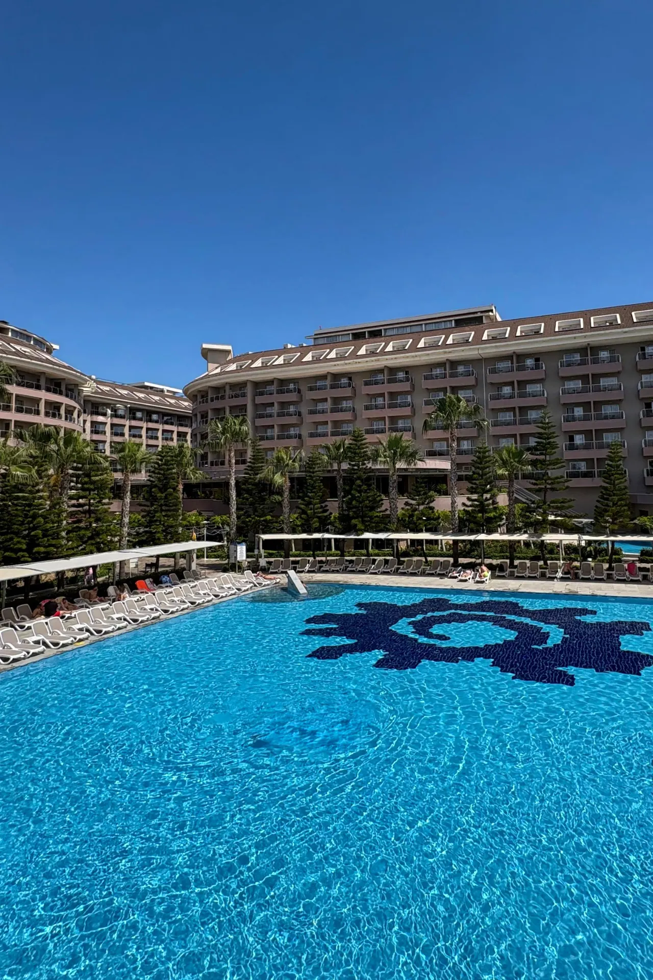 Het grote zwembad van Sunmelia Beach Resort in Turkije met helderblauw water, ligbedden rondom het zwembad en het hotelgebouw op de achtergrond. Dit ruime all inclusive resort aan de Turkse Rivièra biedt volop mogelijkheden voor ontspanning, zwemmen en genieten onder de zon.
