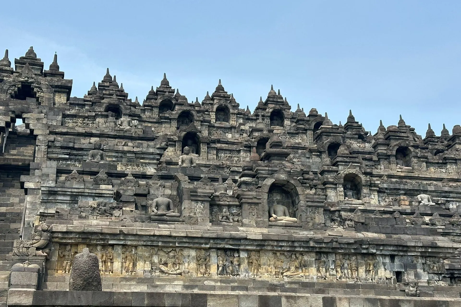 Gedetailleerd reliëf op de Borobudur-tempel, met boeddhistische taferelen en beeldhouwwerken.
