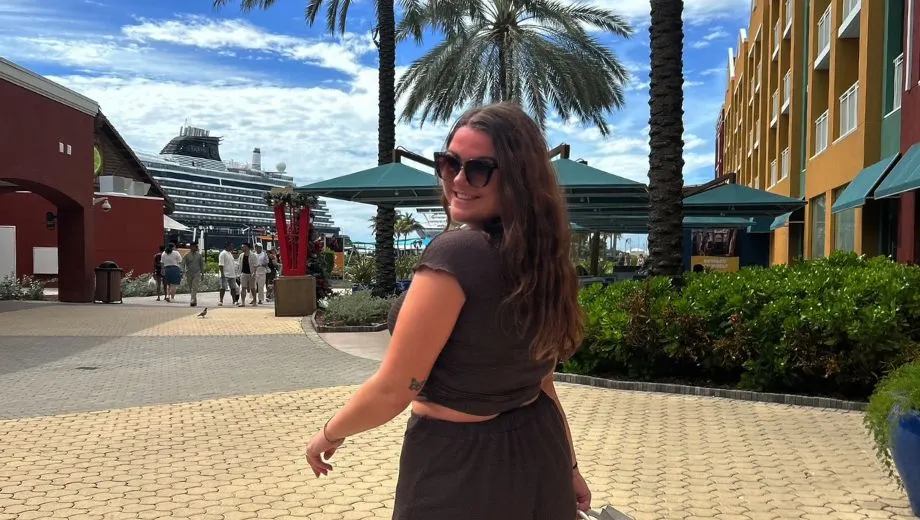 Straatbeeld op Curaçao met kleurrijke gebouwen, palmbomen en een cruiseschip op de achtergrond. Deze levendige omgeving laat de sfeer en veelzijdigheid van het eiland goed zien tijdens een vakantie.